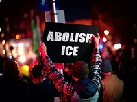Protester holding a sign that says, 'Abolish ICE'