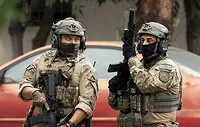 Two men in masks and military gear stalk an LA neighborhood on June 12, 2025