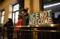 Protester holding a sign that says simply, 'ICE NOT WELCOME'