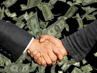 Two people shaking hands in front of a cascade of paper money