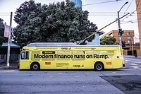 City bus in San Francisco displays an ad for ramp.com with the words, 'Modern finance runs on Ramp.' In smaller text are the words, 'Join the next generation of finance teams at ramp.com,' and 'Control, automate, and streamline your finance operations.'