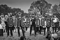 Protesters holding up a sign that says 'Ditch DOGE'