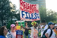 Protesters holding a sign reading 'Release the Jeffrey Epstein Files NOW'