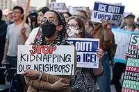 Protesters holding a sign reading 'Stop kidnapping our neighbors