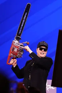 Elon Musk weilding a chainsaw representing his decimation of the institutions of democracy in the United States