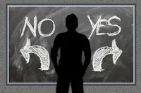 Drawing of a chalkboard with the words 'No' and 'Yes' written on it. A man is shown in silhouette in front of the chalkboard as if trying to decide which to choose.